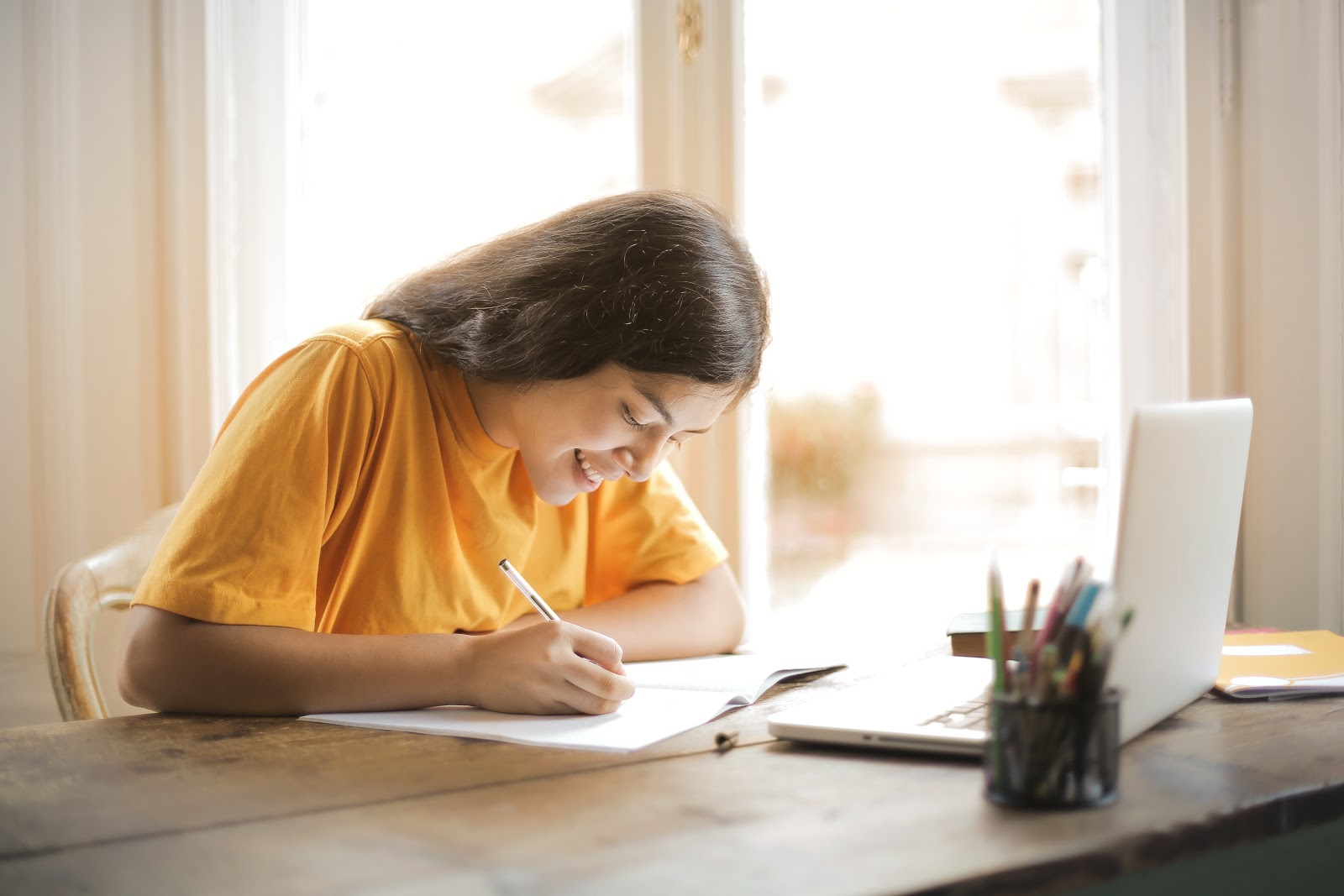 woman-in-yellow-shirt-writing-on-white-paper-3807755